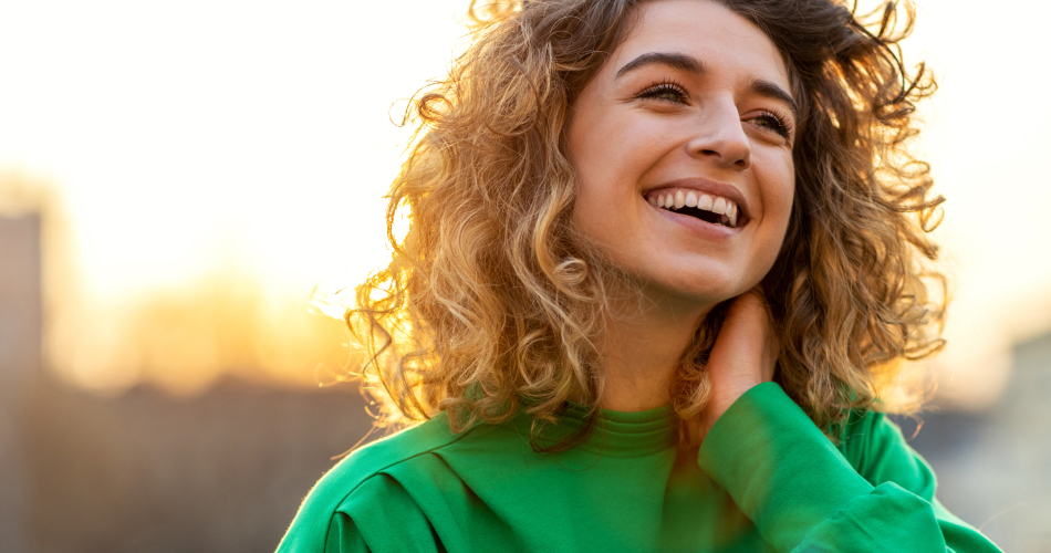Woman smiling, sunset behind her