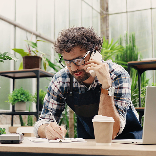 man on phone at desk in a plant shop